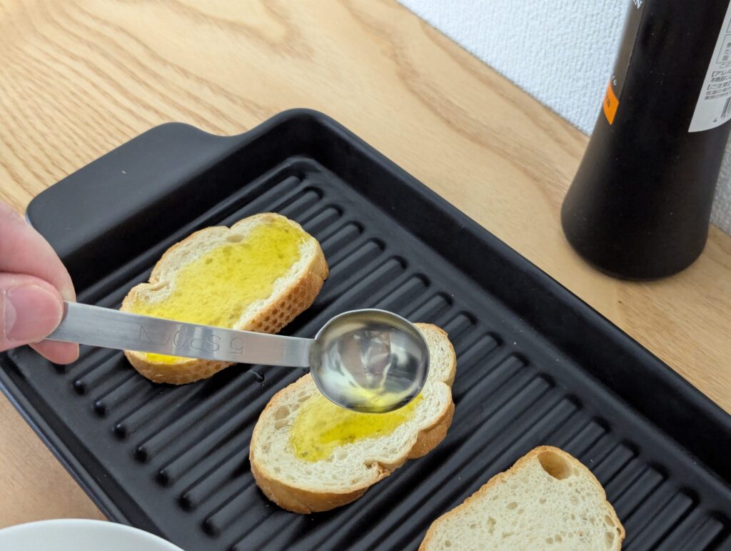 切り分けて軽くトーストしたバケットにオリーブオイルを落としていきます。条件をできるだけ同じにするため、きっちり小さじ1杯ずつ塗りました。